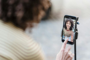 a-lady-using-a- smartphone-mounted on-a-tripod-to-create- video-content