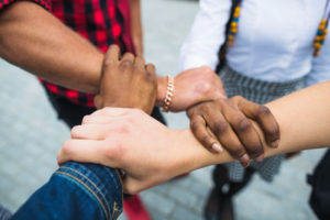 a-group-of-people-holding-hands-together