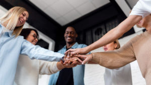 a-group-of-people-joining-hands-together