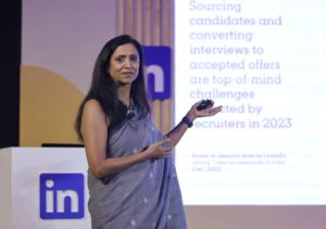 Pooja Gupta standing on a stage and giving a lecture