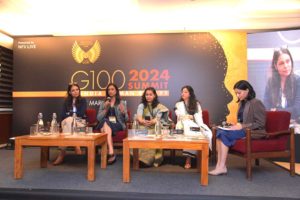 Pooja Gupta surrounded by other women and giving a speech in a summit