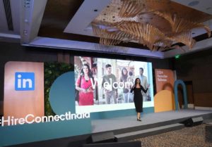 Pooja Gupta standing on a stage and giving an award