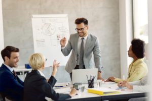 Young-businessman-communicating-with-his-colleagues-during-a-meeting-leadership-theories