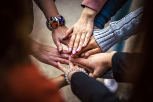 a-group-of-people-joining-hands-together