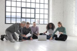 Group-of-People-Sitting-On-The-Floor-While-Working