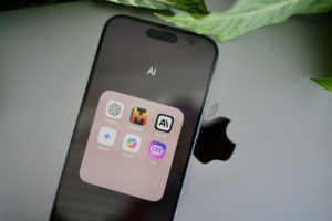 an-iphone-sitting-on-top-of-a-table-next-to-a-leaf