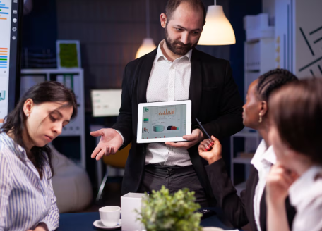 man-showing-presentation-in-front-of-colleagues-on-a-tablet