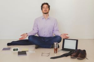 Businessman meditating on floor