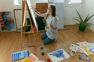 -girl-painting-at-a-canvas-in-her-living-room