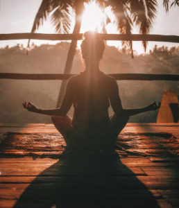 woman-doing-yoga -meditation-on- brown-parquet -flooring