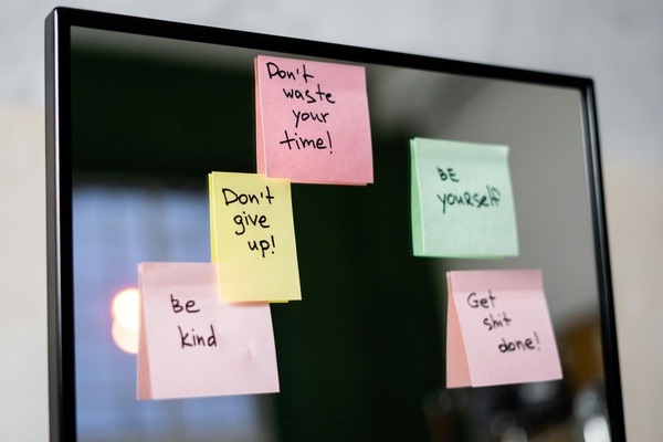 Colorful sticky notes with motivational messages on a mirror reflecting positivity