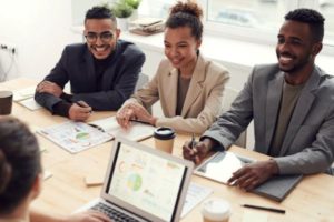 photo-of-three-people-smiling-while-having-a-meeting