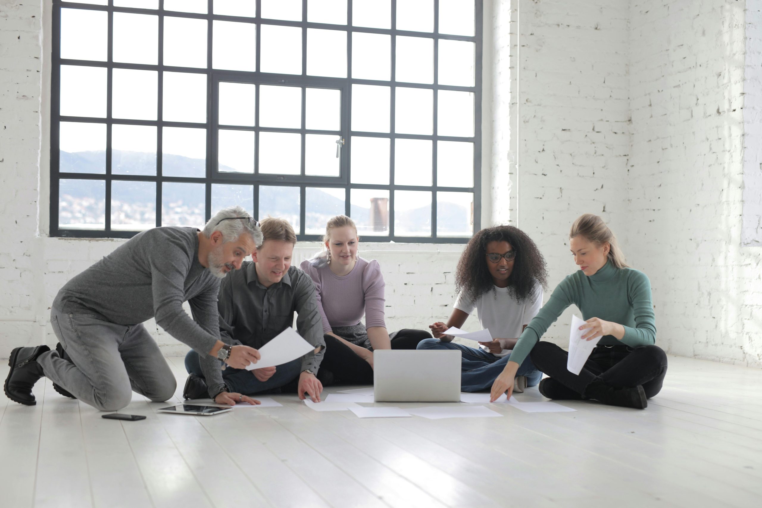 Group of People Sitting On The Floor While Working Group-of-People-Sitting-On-The-Floor-While-Working
