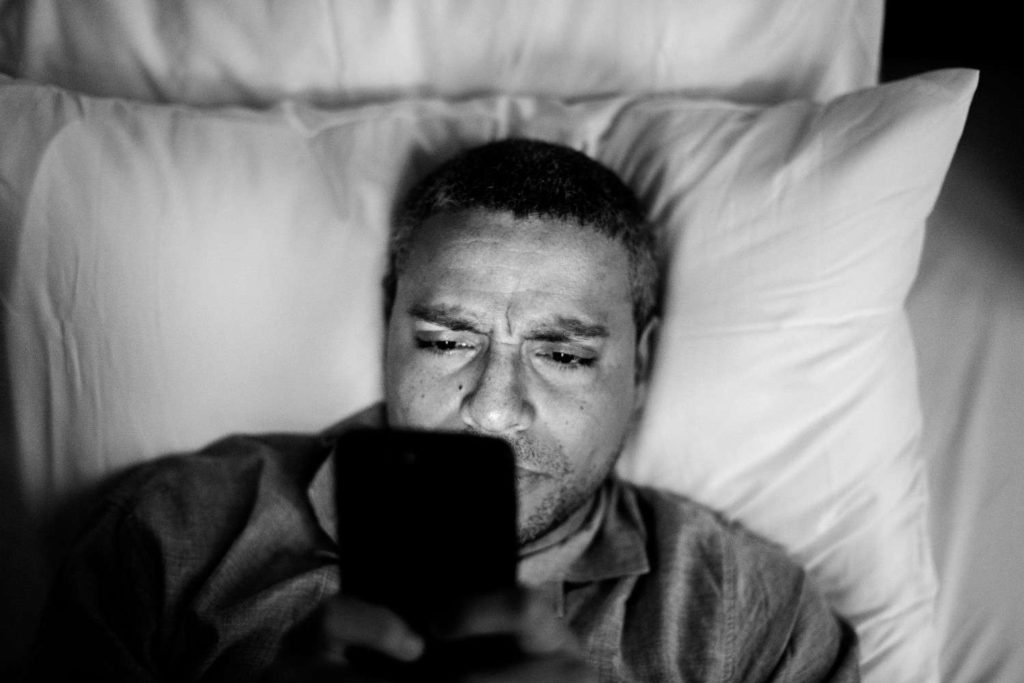 man-doomscrolling-on-phone-at-night