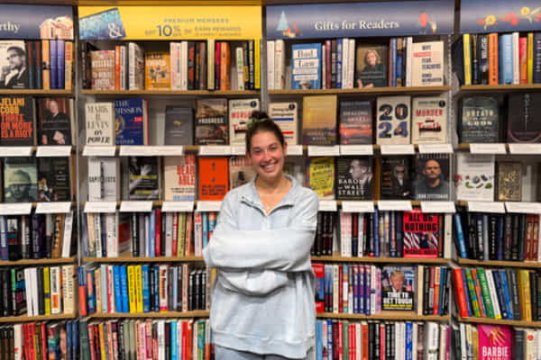 sophie-joseph-standing in-front-of-a-huge-book-shelf