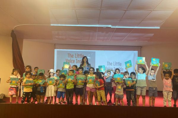 an-image-of-rhea-jabbour-on-a-stage-with-a-bunch-of-children