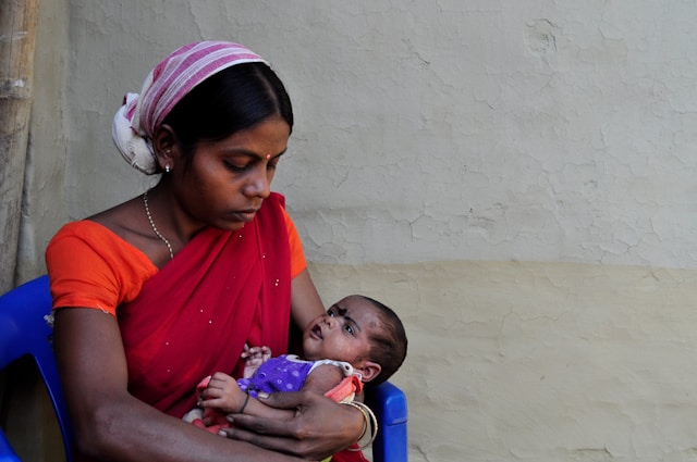 woman-in-red-shirt-carrying-baby