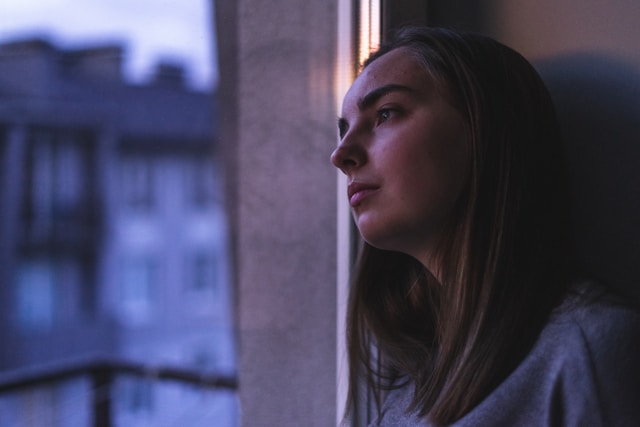 woman-in-white-shirt-looking-at-the-window-during-daytime