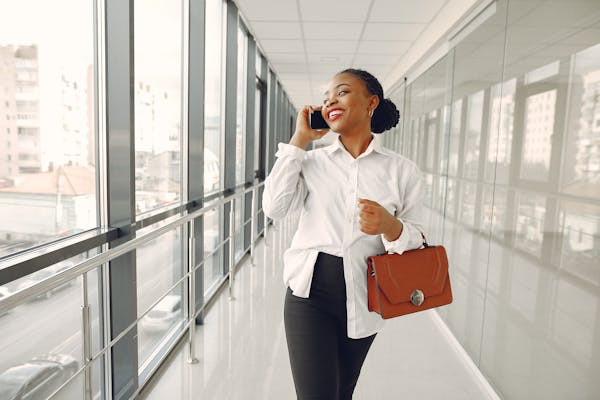 cheerful-woman-talking-on-smartphone-in-modern-office-building