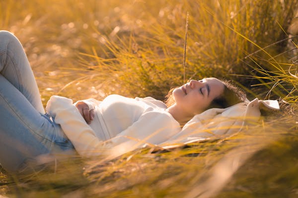 young-woman-relaxing-in-golden-grassy-field