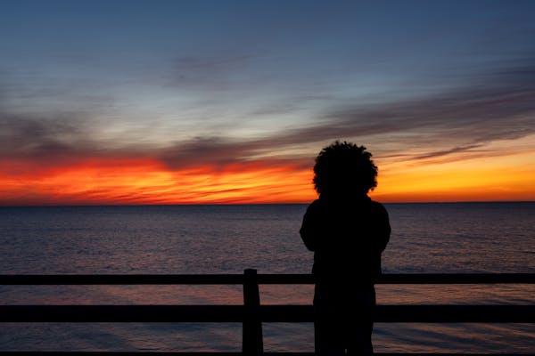 silhouette-watching-sunset-over-ocean-horizon