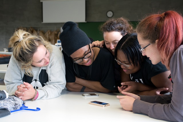 five-women-front-of-tables-with-two-smartphones