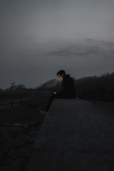 a-man-sitting-on-concrete-bench
