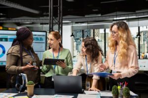 Diverse team of women collaborating on a business project, addressing the confidence gap in the workplace. 