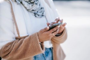 A woman scrolling through her phone, representing how digital platforms make marketing manipulation faster and more personal than ever