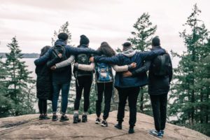 A group of friends embracing while looking at scenery, illustrating the importance of meaningful relationships and social connection.