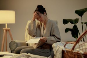 A woman feeling overwhelmed with paper in hand