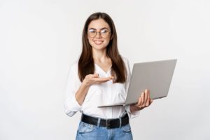 woman in glasses holding laptop