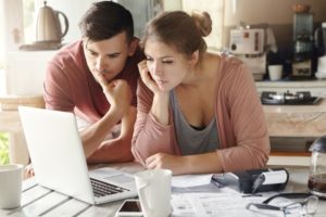 serious man and woman sitting in front of a laptop
