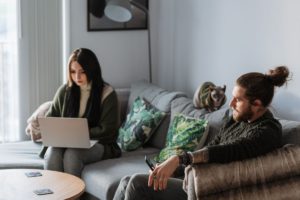 Couple enjoying time together at home while working on their individual activities
