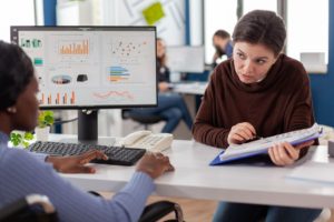 image of two women working on salary benchmarking based on data graphs