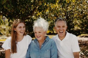Grandmother, mother and daughter sitting together outdoors