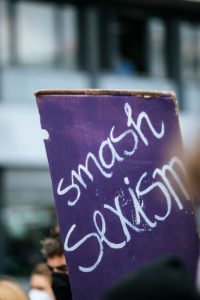 A protest sign reading “Smash sexism” held during a public movement