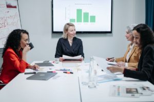 Women sitting in a meeting room with papers on the table 