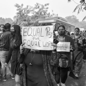 A woman holding a slogan saying equal pay for equal work