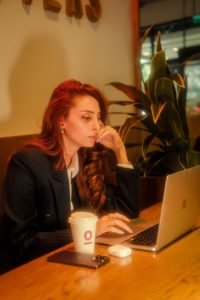 Woman working on her laptop with a calm, focused expression in a cafe 