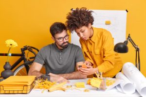 image of a guy and girl working together under high paying creative career