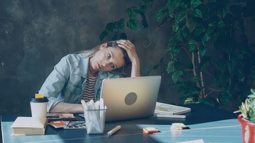 woman tired in front of laptop