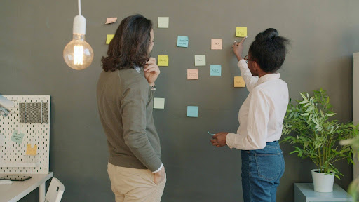 Two colleagues discussing ideas on colorful sticky notes