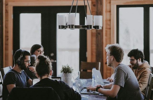 people sitting at a table discussing. 