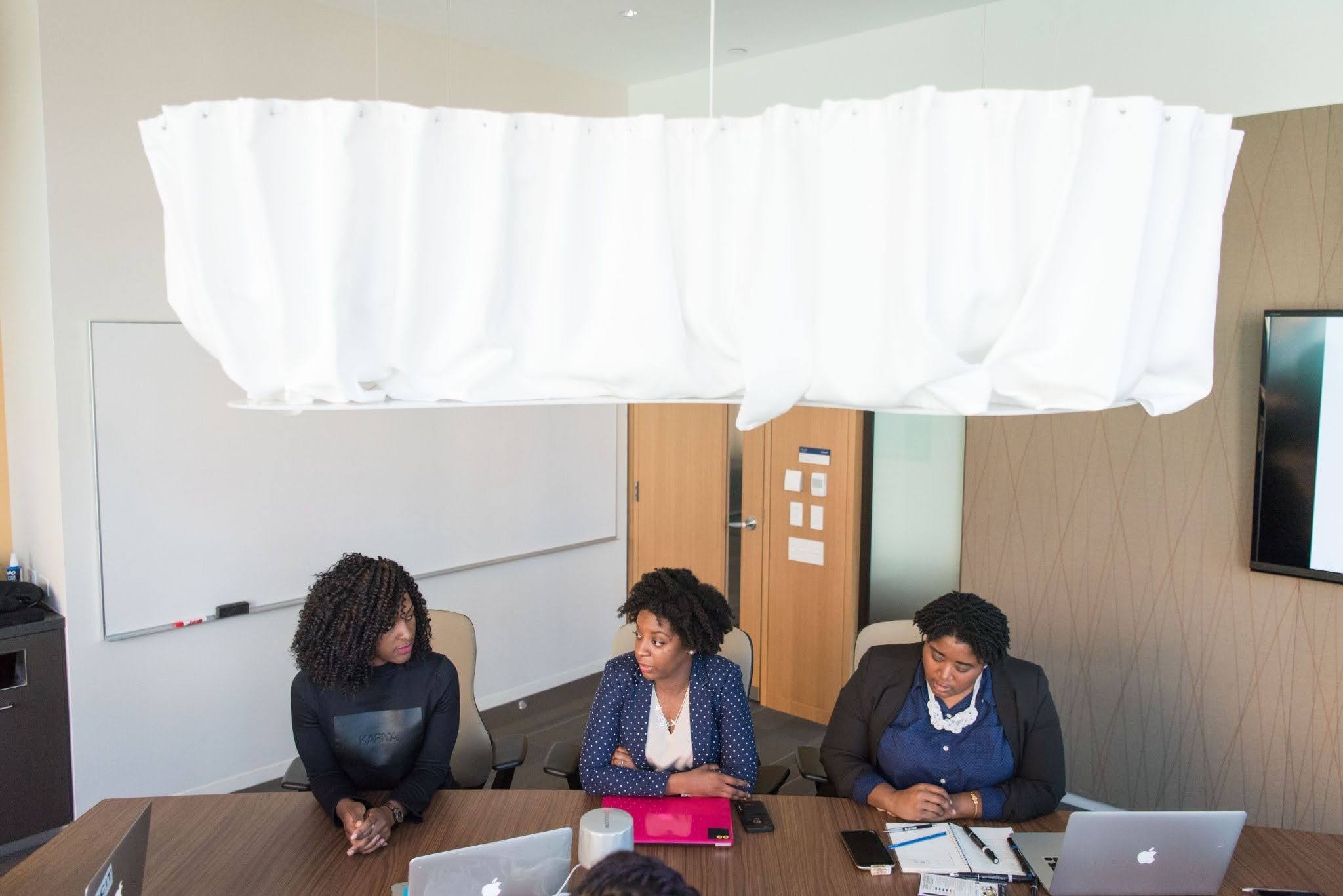 A diverse group of women in a boardroom setting, illustrating the declining representation of women in senior leadership roles.