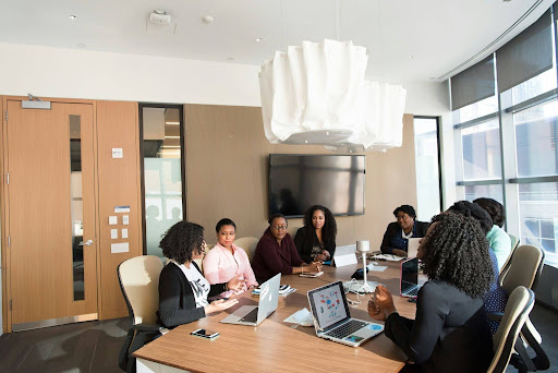 A mixed-gender leadership team collaborating in a meeting room, representing organizations that are actively supporting women’s career advancement.